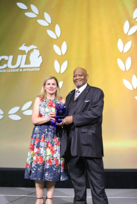 Raymond White Jr. receiving the MCUL Board Member of the Year award on stage